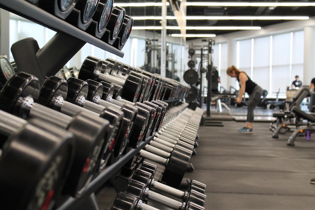 woman-standing-surrounded-by-exercise-equipment-cqfnt66ttzm